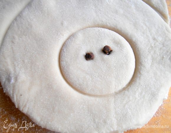 Для дырочек в пятачке ломаем две гвоздички пополам и втыкаем в тесто.