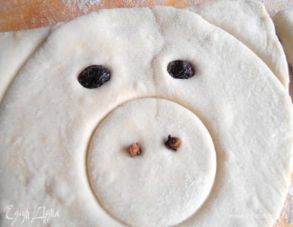 Для глазок втапливаем в тесто две изюминки.