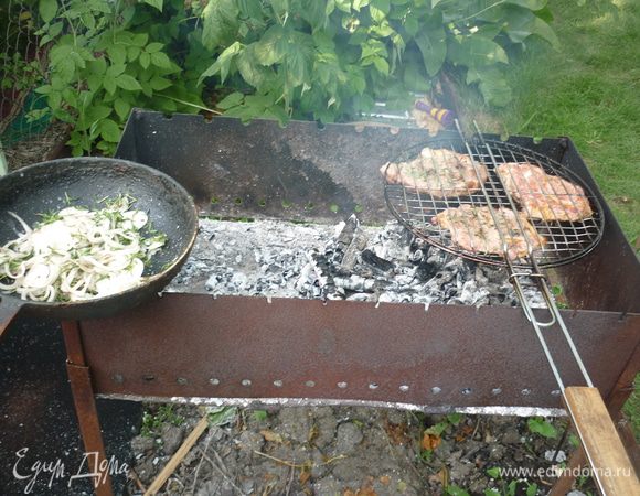 Решетку с мясом регулярно переворачиваем для равномерной прожарки. и когда мяско уже золотистое, на горячую сковороду высыпаем лук. он не должен жариться, а лишь немного прогреться, стать добрым и мягким