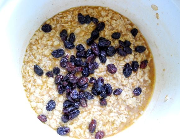 В заваренную массу из овсяных хлопьев добавляем соль, сахар, оливковое масло, размешиваем, накрываем салфеткой и оставляем на некоторое время.
Когда смесь остынет, но будет ещё достаточно теплой (чтобы пальцы чувствовали приятную теплоту чуть-чуть), добавляем раскрошенные свежие дрожжи или сухие, изюм, размешиваем. 