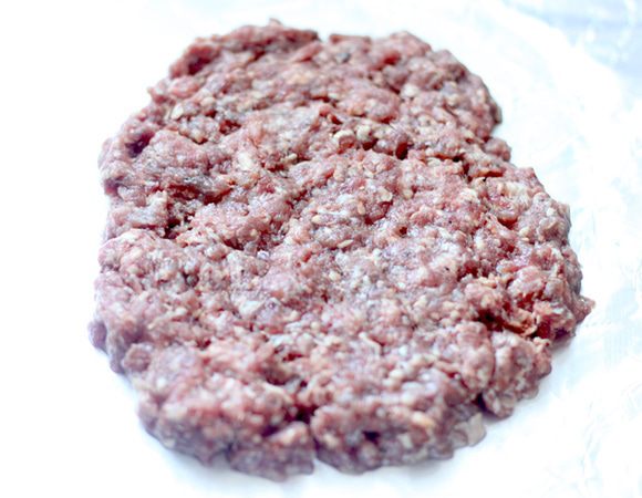 Выложить 2/5 фарша на смазанную поверхность в форме овала.