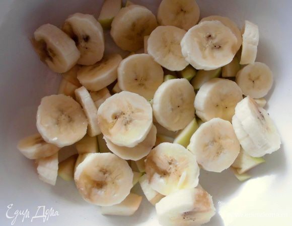 Из яблока удалить сердцевину и нарезать довольно крупными кусочками. Банан нарезать ломтиками и добавить в миску к яблоку.