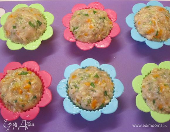 Руками, смоченными в холодной воде, сформировать из куриного фарша небольшие шарики. Разложить по формочкам.