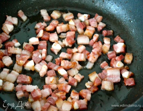 На сковороде без дополнительного масла обжариваем кубики бекона. Перекладываем на горячее блюдо и отставляем в сторону. 