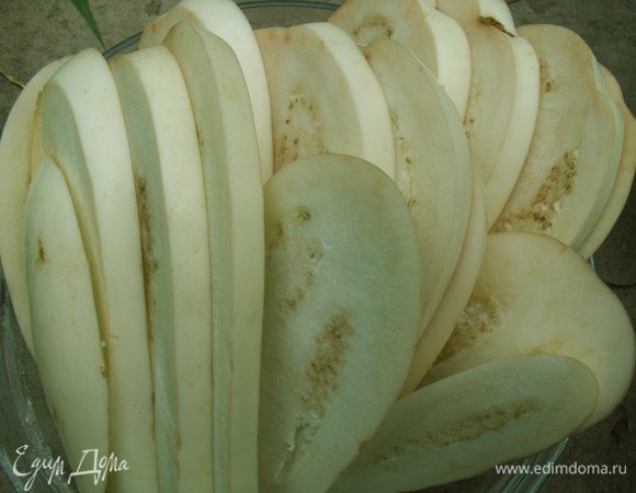 Баклажаны нарезаем вдоль толщиной около 1 см. Духовку разогреваем на 180С. Кладём баклажаны в духовку на решётку. Если у Вас есть сковорода-гриль, то великолепно их обжарить именно на ней. Также можно пожарить на обычной сковороде на масле, но слишком много масла берут баклажаны, а летом хочется легких блюд. Баклажаны запекаем до мягкости.Мне понадобилось 20 минут. Баклажаны я никак предварительно не обрабатывала, потому что белые вообще не горчат. Если у Вас обычные, то после того, как Вы их нарезали, посолите их и дайте постоять, пока они не дадут сок (минут 20 обычно), промойте и отожмите, а потом обжаривайте.