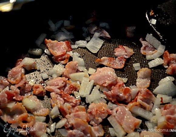 Разогреем  антипригарную сковороду. Выложим порезанный бекон. Обжариваем до хрустящего вида. Добавим лук и обжариваем еще 5 мин.