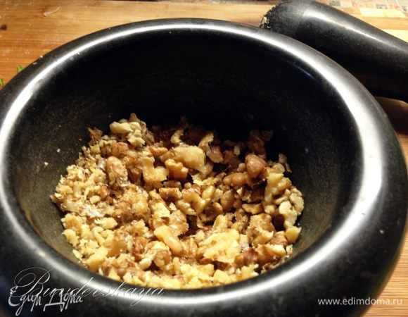 Грецкие орехи немного растолочь в ступке или крупно порезать ножом.