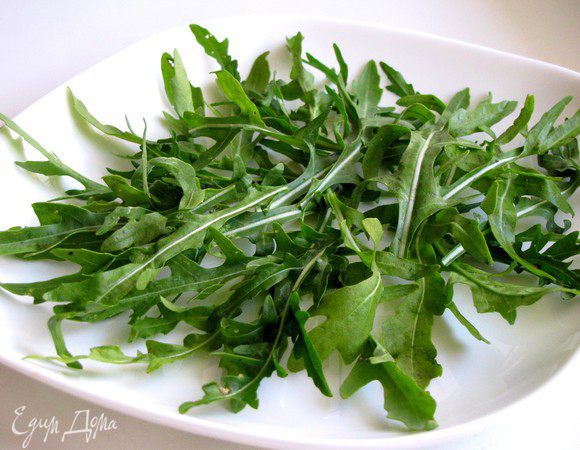 Руколу промойте, обсушите и выложите на тарелку.