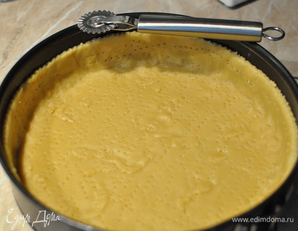 Разъёмную форму d 26 см смазать растительным маслом.
Тесто раскатать в пласт толщиной 3-4 мм, выложить им дно и бортики формы и наколоть его вилкой. Бортики желательно сделать повыше, чем у меня, тогда вместится всё заявленное количество вишни (1,5 кг) . Чтобы они смотрелись аккуратнее, можно пройтись по верхнему краю бортика ножом для пиццы.
Форму с тестом на то время, пока разогревается духовка, убираем в морозилку. Песочное тесто не должно "расслабляться":)


