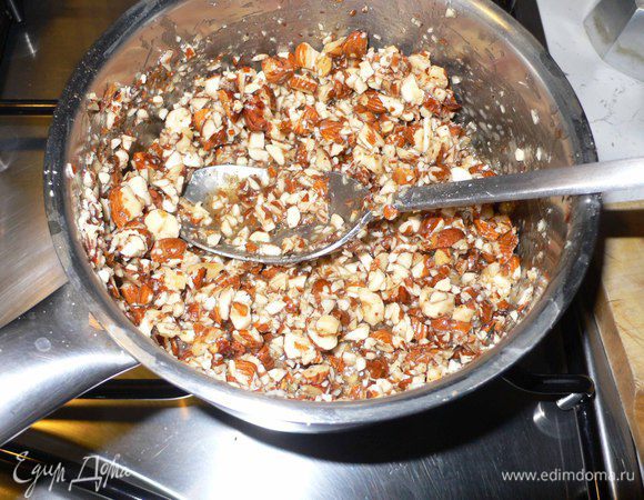 Мед ставим на огонь и добавляем 3 ст ложки вина и смесь специй. Даем покипеть 1 минуту. 
Добавляем орехово-изюмную смесь. Подвариваем в меде около 2 минут. 