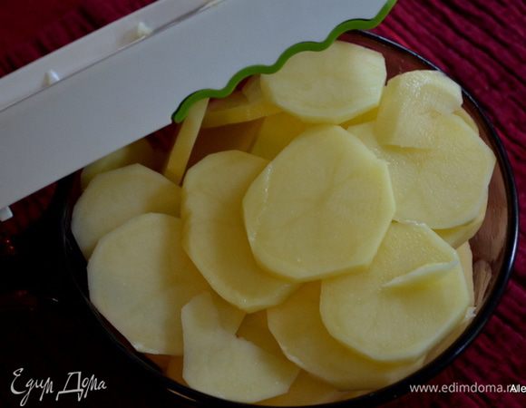 Разогреть духовку до 190 гр.
Смазать жаропрочное блюдо 2 стол.л олив.масла. Картофель очистить и нарезать тонко,применяя слайсер или вручную.
