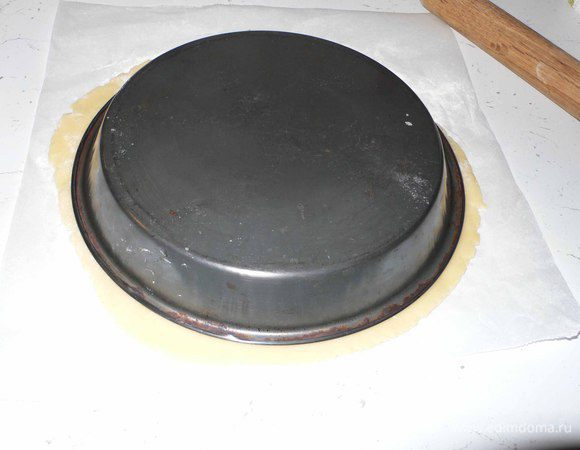 Чтобы аккратно уложить тесто в форму делаем так. На небольшую разделочную доску ложим лист бумаги с раскатанным тестом. Накрываем его сверху формой, подсовываем ладонь под  доску и быстрым движением переворачиваем. 