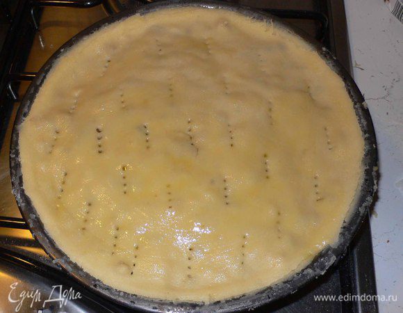 Накрываем вторым диском и накалываем вилкой.  Затем ножом проходим по краям, таким образом обрезая лишнее.  Поверхность обмазываем оливковым маслом. 