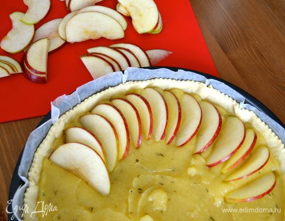 Два красных яблока, не очищая кожуры (удалите только сердцевину с косточками), нарежьте тонкими дольками и выложите их по кругу на поверхности пирога.