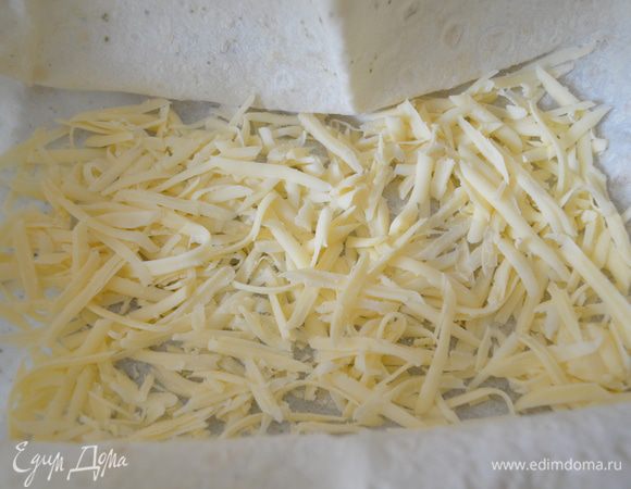 На дно формы с лавашом раскладываем 1/3 часть сыра.