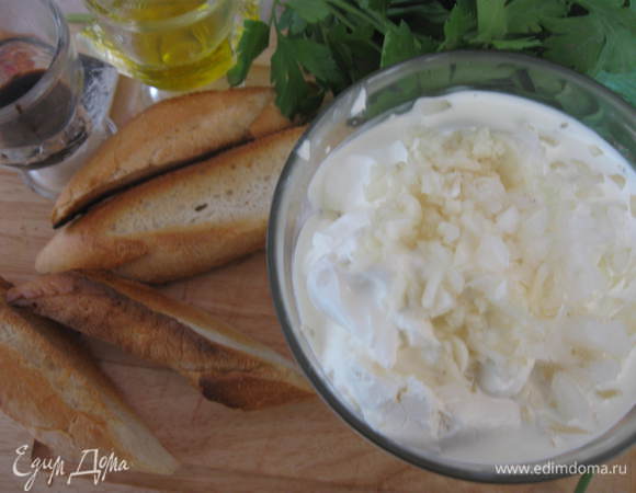 Багет порезать на куски, обжарить. Творог смешать со сливочным сыром, добавить сливки. Взбить. Добавить репчатый лук и чеснок. Перемешать.