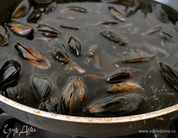 Отварить мидии буквально 5-7 минут в небольшом количестве кипящей воды в большой сковороде (можно добавить немного белого вина). Мидии от такой термообработки откроются, и это поможет нам с легкость их разделить на половинки. Через 5 минут достать мидии шумовкой из сковороды, переложить в миску и дать им остыть. Жидкость от сваренных мидий не выбрасывать. Чуть позже нам понадобиться примерно 3/4 стакана отфильтрованной жидкости...