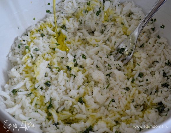 Духовку разогреть на 220 С. Подготовить заранее отваренный рис. Добавить в него половину тертого сыра, петрушку, ложку сушеного чеснока, соль, перец по вкусу и заправить 30 мл масла. Равномерно перемешать.