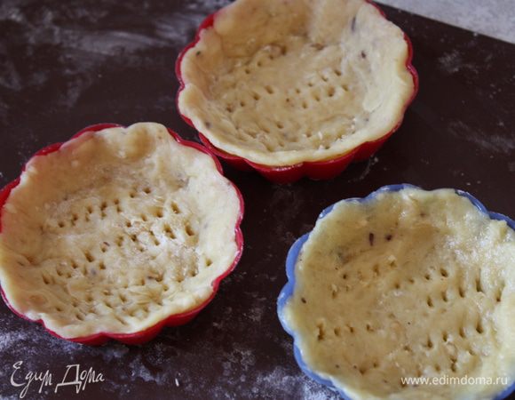 Также выкладываем тесто в маленькие формочки и вилкой делаем дырочки.