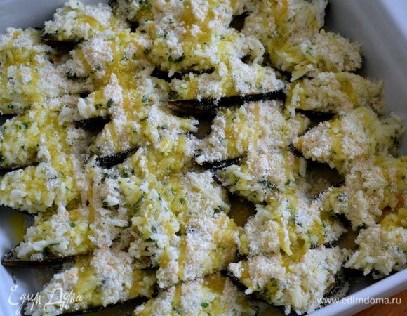 Сухари и оставшийся тертый сыр смешать. Половиной от этой смеси присыпать сверху мидии, и сбрызнуть оливковым маслом.  