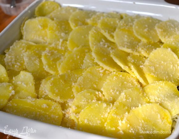 Выложить слой картофеля поверх мидий. Немножко внахлест, наподобие "чешуек". Сверху сбрызнуть опять немного маслом. Оставленную нами жидкость от варки мидий осторожно налить по углам формы для выпечки. ("на глаз", у меня ушло чуть меньше стакана (200 мл))