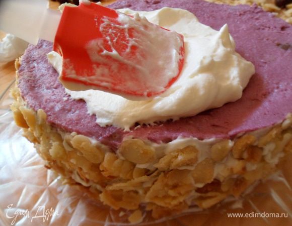 Обмазываем сливочным кремом бока и верх торта. Украшаем карамелизированным миндалем бока