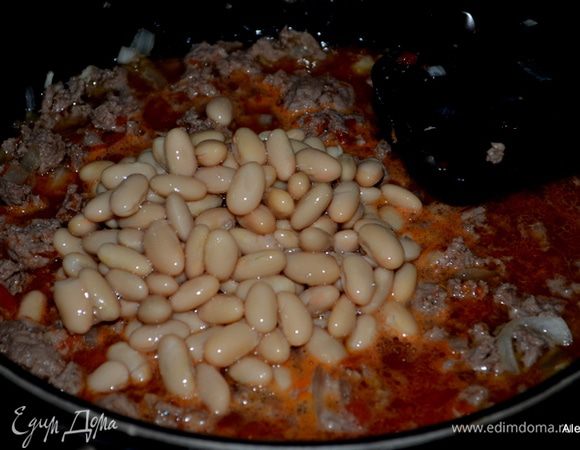 Добавить ингредиенты :2 ч.л соль,
1 бутылка пива или эля,
400 г томаты в банке целые или порубленные,
400 г белая фасоль готовая в банке,
240 г пинто фасоль,
3 стол.л чили порошком,
1 ч.л карри,
1/4 ч.л имбирь на терке,
140 г.мед жидкий.
 в общую массу. 
Белая готовая фасоль из банки выглядит таким образом.  Перемешать и довести до кипения, убавить огонь и тушить примерно 30 мин. часто помешивая. У меня вышло дольше по времени.