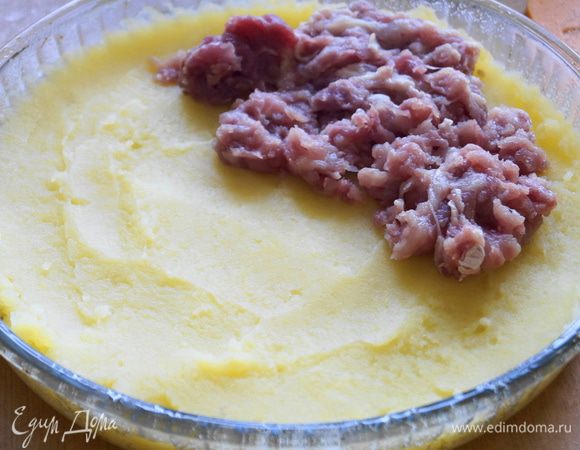 Форму для запекания смазать маслом и немного присыпать манной крупой. Выложить ровным слоем весь картофель. Затем мясной фарш и разровнять по всей поверхности.