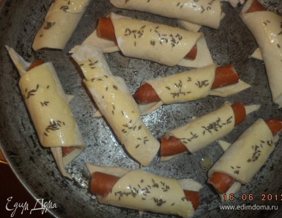 Теперь выкладываем наши рулетики на противень.Смазываем их взбитым яйцом, посыпаем тмином. Выпекаем при температуре 200 градусов 12-15 мин.