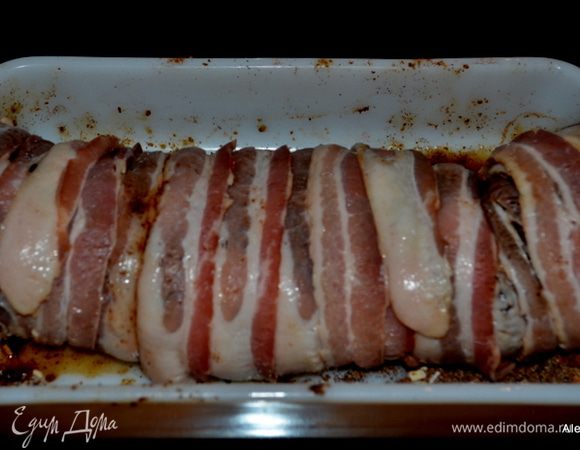 Разложим бекон так чтоб полоски были немного друг на друге по краям. Выложим наш кусок свинины в специях и запеленаем в бекон. Выложим в жаропрочное блюдо и готовим примерно 45 мин. в духовке.