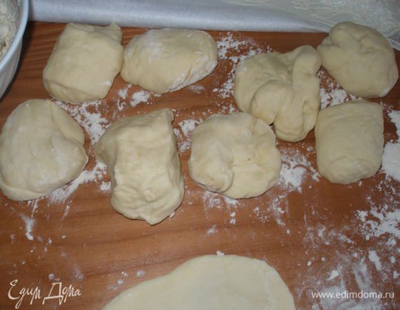 Выложить тесто на притрушенный мукой стол и немного его обмять. Разделить его на одинаковые кусочки и скатать из них шарики.