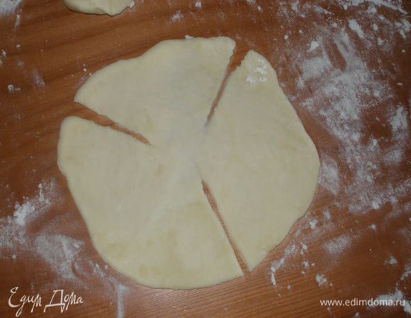 Каждый шарик раскатать в лепешку диаметром около 15 см и сделать три надреза. Один из надрезов должен быть меньше двух других.