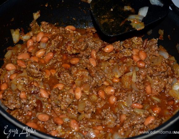  Разогреть духовку до 200 гр.
На разогретой сковороде обжарить лук, добавить  фарш и обжаривать вместе. Добавить затем томатный соус и Тако специи, фасоль,перемешать все вместе несколько минут.