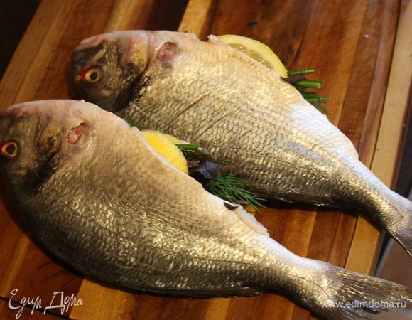 "Начиняем" наших рыбок. В брюшко кладем зелень (я в три раза просто свернула веточки) и по паре ломтиков лимона.