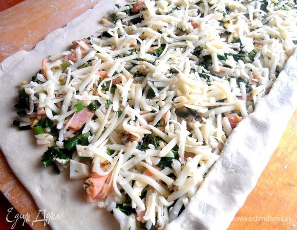 Начинаем сворачивать рулетик, прижимая край теста к начинке...