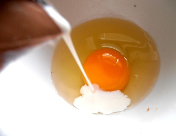 В сырое яйцо добавляем чуть сливок...