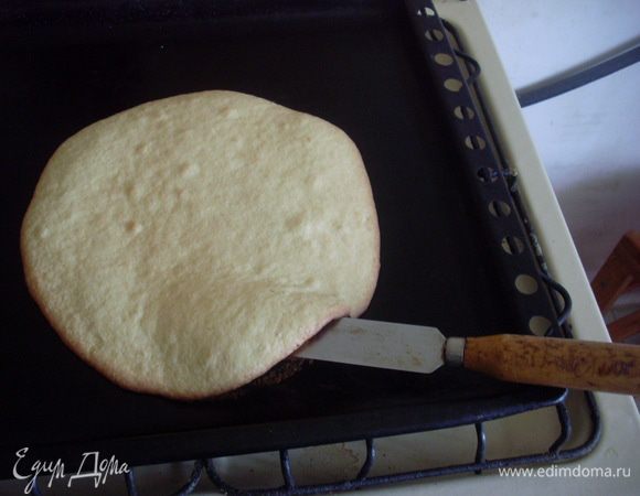 Пока горячий, обрезать корж по диаметру донышка формы, желательно сильно не придавливать, а то тесто прилипнет к донышку. Провести длинным гибким ножом или специальной лопаточкой под коржом и оставить его остывать. 
Выпечь еще один корж. (Что делать с остатком теста - на ваше усмотрение, я сразу пеку в виде больших клякс вокруг коржа).