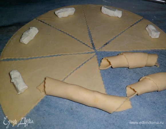 В каждый треугольник я положила половинку сырка и свернула в рогалик