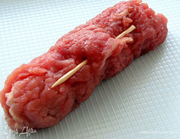 Свернуть мясо в рулет и скрепить зубочисткой.