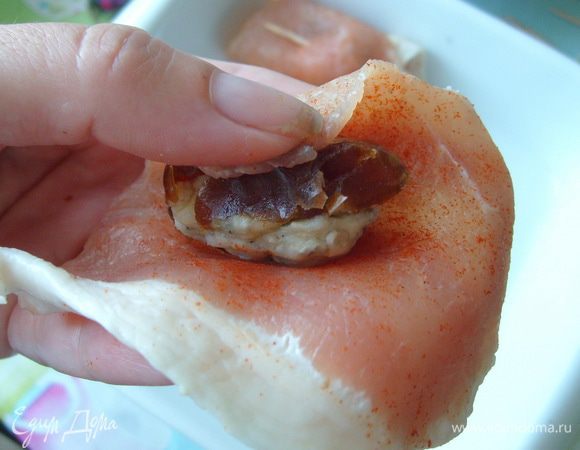 Завернуть фаршированный финик в тонккую полоску свинины. Заколоть зубочисткой.