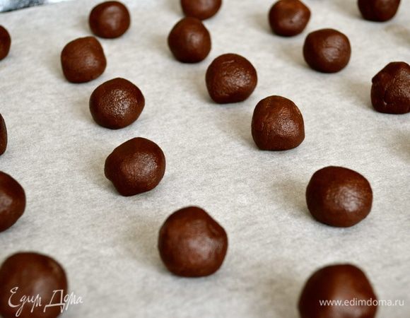 По истечении указанного времени, включить духовку на 180 С. Достать тесто из холодильника и сформировать небольшие шарики одинакового размера. Выложить их на противень, застеленный пекарской бумагой (у меня получилось 2 заполненных противня).