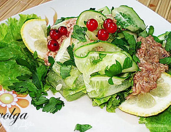 На тарелку положить листья салата, сверху полоски огурца, петрушку и тунец. Можно добавить перец. Полить лимонным соком. Украсить ягодами красной смородины.