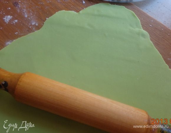 Раскатать часть зеленой мастики для нижнего коржа с таким расчетом, чтобы в центре осталось пространство для синей вставки. 