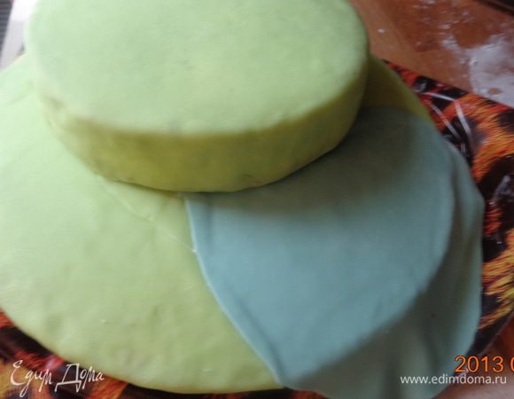 Раскатать часть синей мастики и уложить ее между зеленой. Так же сделать и средний корж.