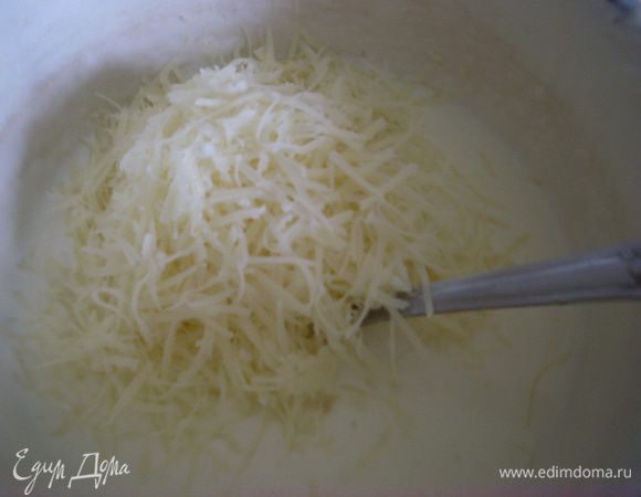 Сварить сливочно-сырный соус. Прогреть муку на растопленном сливочном масле. Добавить молоко и сливки, довести до кипения. Если остались комочки, протереть через сито и снова прогреть. Добавить натертый сыр, перемешать, чтобы он расплавился.