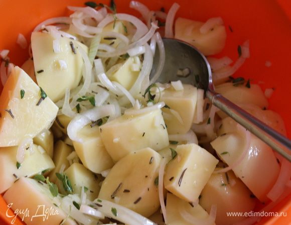 Лук нарезаем полукольцами, чеснок (3 зубчика) тоже мелко режем. Чистим и режем картофель на небольшие кусочки. Добавляем к картофелю, луку и чесноку травки с 4 ст.л. оливкового масла. Тщательно все перемешиваем и через 15 минут после начала запекания кладем к нашей курице.