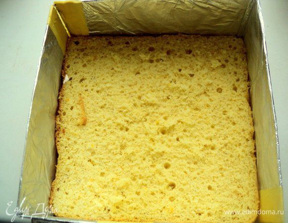 Выпекать при температуре 180 градусов 25 минут. Готовый бисквит охладить на решетке и разрезать на два пласта. Одну часть бисквита положить в форму или на блюдо, установив бортики.