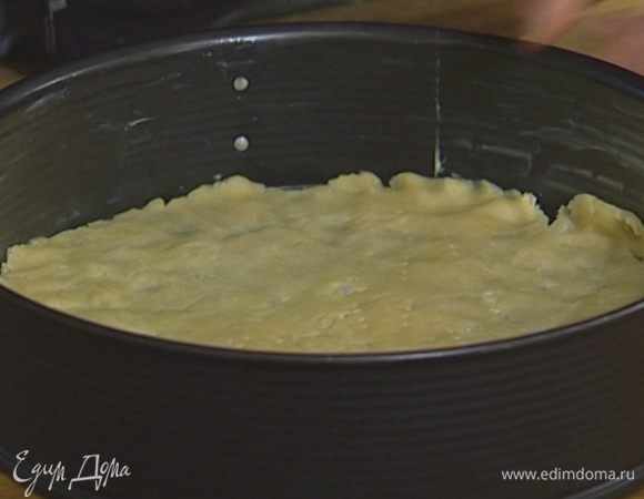 Смазать сливочным маслом форму для выпечки. Тесто поместить между двумя листами бумаги для выпечки и раскатать как можно тоньше, выложить его в форму, проткнуть вилкой в нескольких местах и отправить в разогретую духовку на 5 минут.