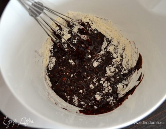 Далее, перемешивая венчиком (можно воспользоваться и электромиксером), просеять в шоколадную смесь муку. Как следует перемешать.