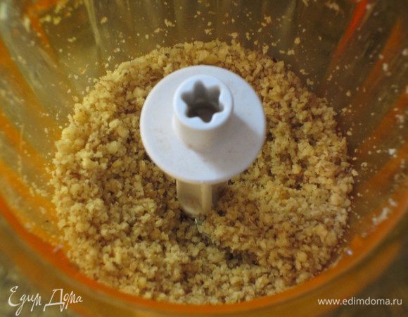 Орехи измельчить в блендере. Зелень петрушки порубить.